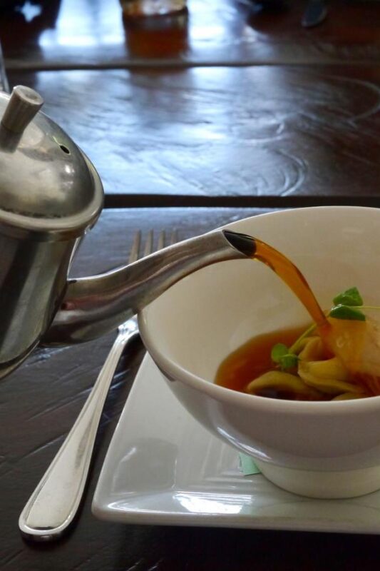 Pouring hambone broth over country ham tortellini at Harvest in Louisville