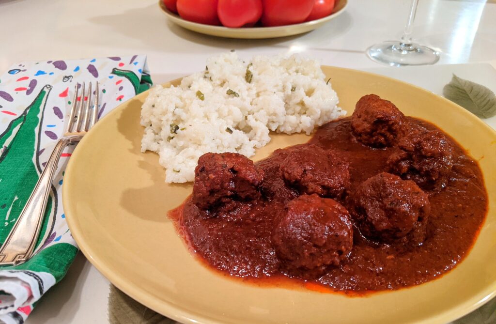 Mole coloradito with meatballs and rice grits